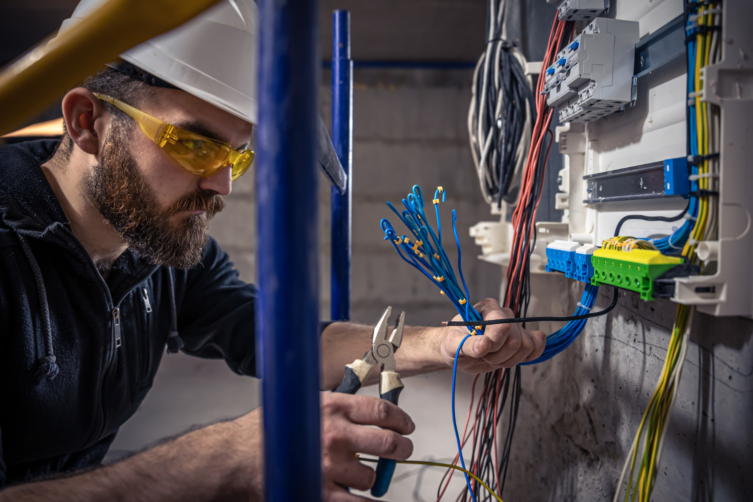 Électricien rl-services ajustant un tableau électrique sécurisé dans une installation professionnelle dans le Tarn