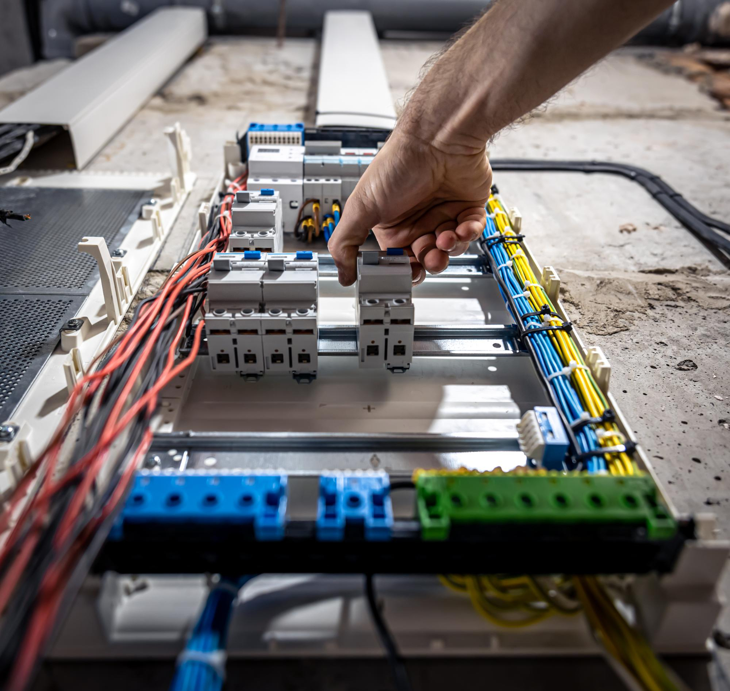 Électricien rl-services réglant un disjoncteur sur tableau électrique industriel dans le Tarn