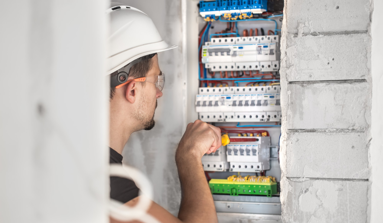 Électricien rl-services réglant un tableau électrique encastré sur chantier neuf dans le Tarn