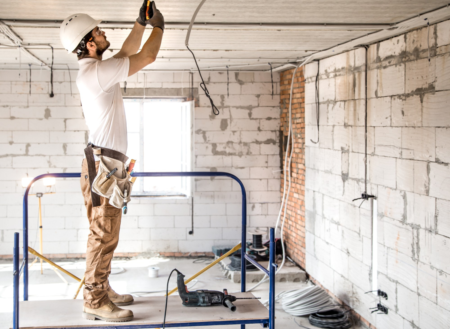 Électricien rl-services installant des câbles sur chantier intérieur en rénovation dans le Tarn