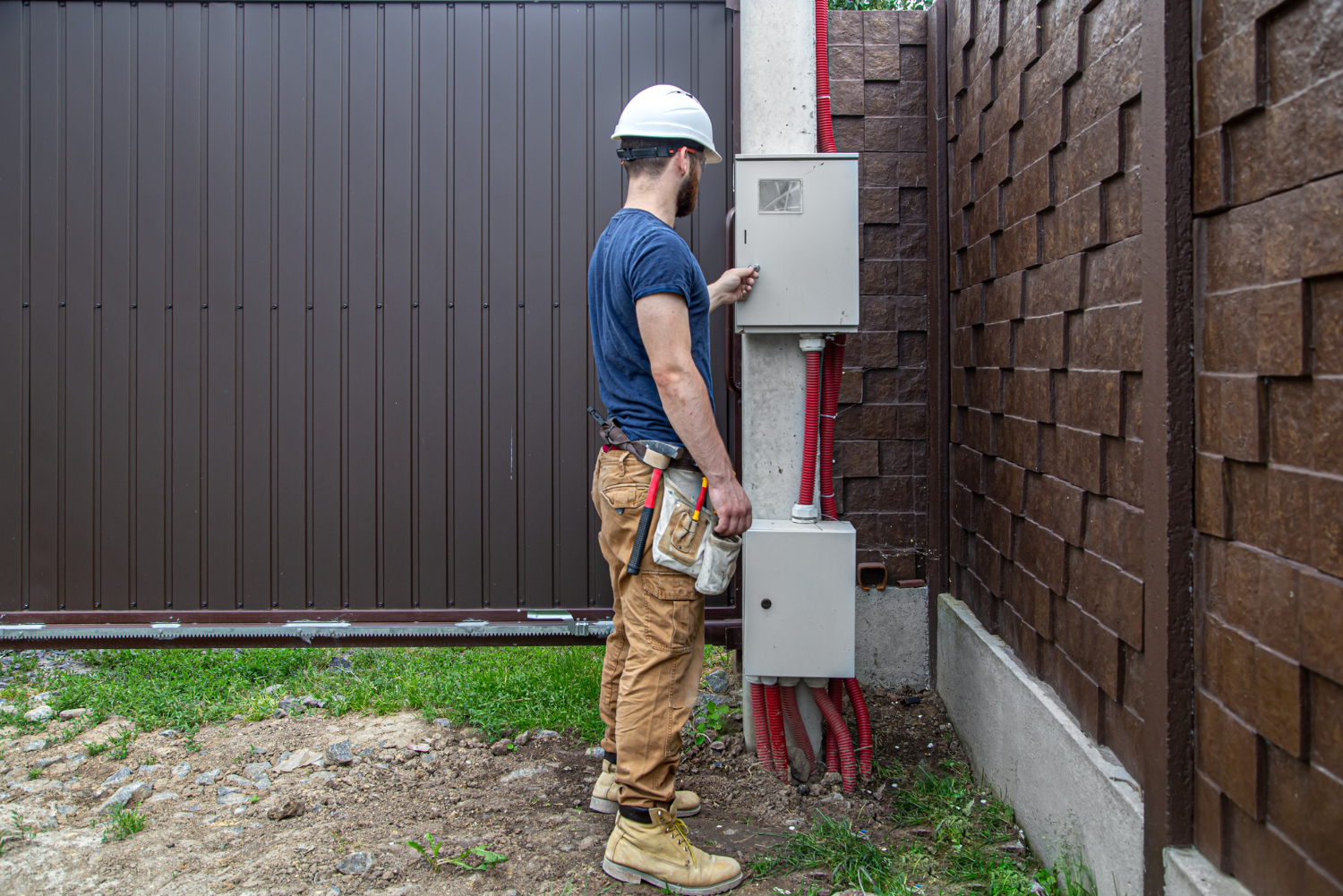 Électricien rl-services installant un coffret électrique extérieur sur chantier résidentiel dans le Tarn