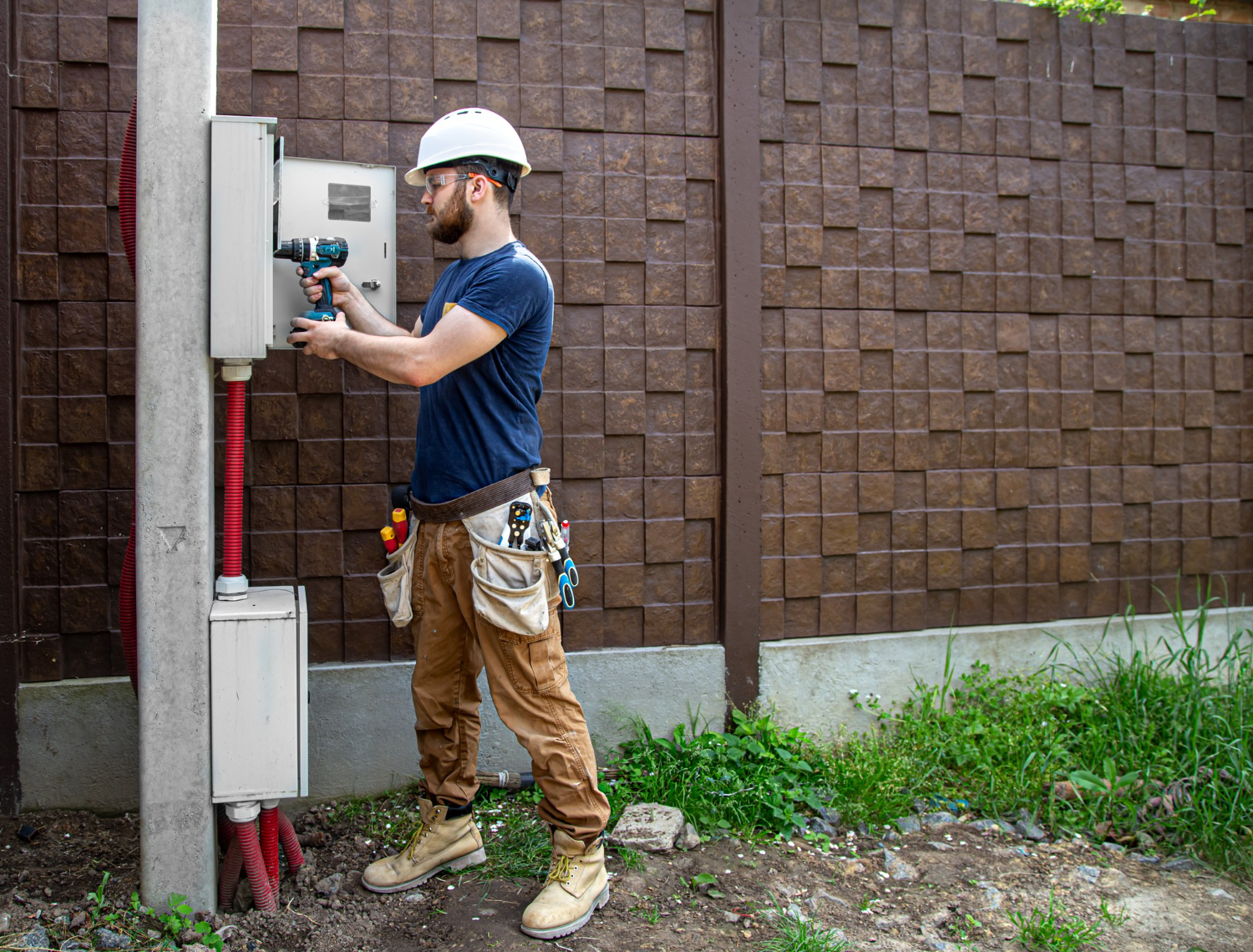 Électricien rl-services au travail sur boîtier extérieur, intervention sécurisée en plein air dans le Tarn