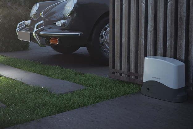 Portail coulissant motorisé par rl-services protégeant une voiture de collection dans un jardin moderne du Tarn