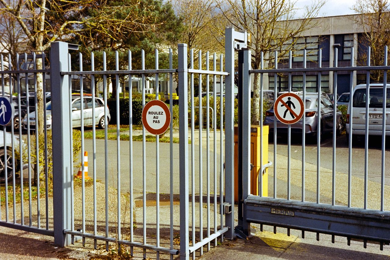 Barrière de parking sécurisée avec panneau ROULEZ AU PAS pour rl-services près d’un parking voitures dans le Tarn